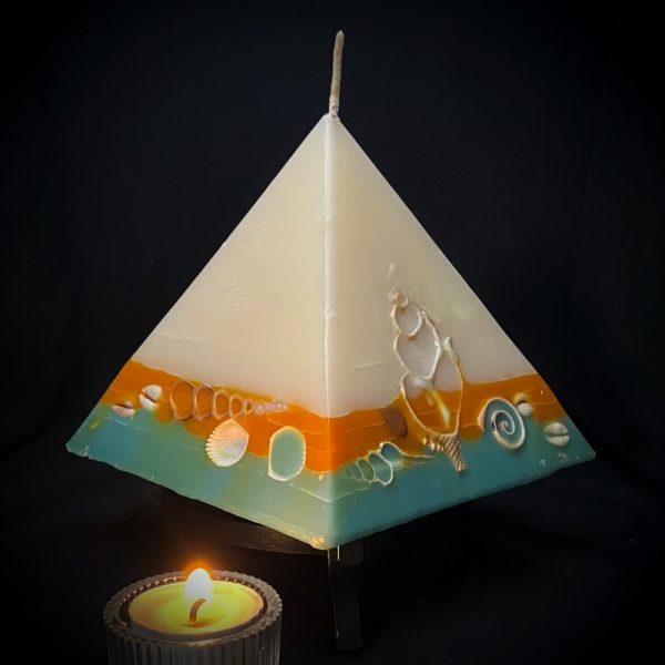 Nefertiti: mid size in our pyramid range burning over 150 hours. Take me to the beach please! Fresh, warm and tropically scented this range is infused with essential oils of lime and coconut. White in colour, these candles feature an sunburnt orange and teal banded base embedded with sea shells. As you near the end of your candle's burning, the trove of exotic shells is revealed - your lasting keepsake.