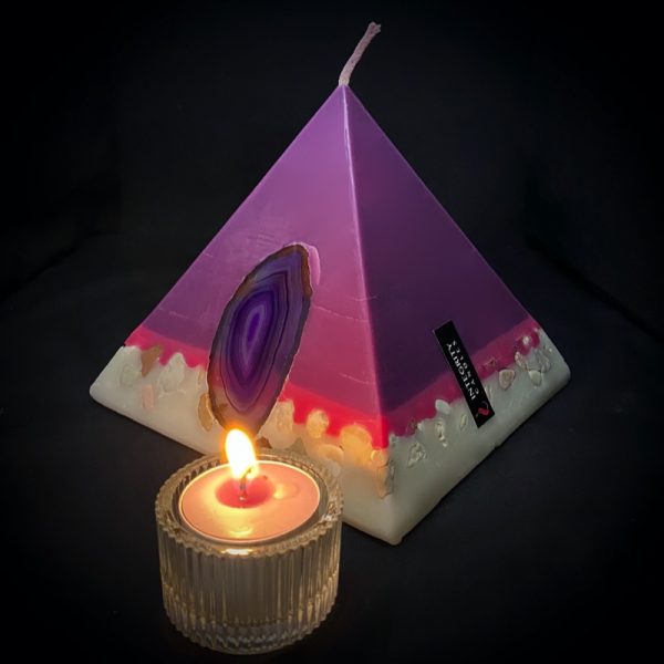 Nefertiti: mid size in our pyramid range and burning over 140 hours. Deeply relaxing, essential oils of Lavender, Patchouli, Citrus, Marjoram, Jojoba, Geranium and Chamomile are presented in a meditative shade of purple. A band of magenta sits above a white base embedded with agate slices and river pebble. As your pyramid candle burns, the flame illuminates the Agate slice, revealing the stone's unique variegated pattern, and leaves you with gorgeous keepsakes.