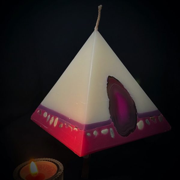 Nefertiti: mid size in our pyramid range and burning over 140 hours. As your pyramid candle burns, the flame illuminates the Agate, revealing the stone's unique variegated patterns, and leaves you with a gorgeous keepsakes. Visually beautiful, this white bodied pyramid is banded at the base in purple and magenta and embedded with agate slices and river pebble. Infused oils of Rose and Geranium oils create a luxurious scent with fresh and relaxing overtones. Our candles illuminate brightly and boast an exceptionally long burn time.