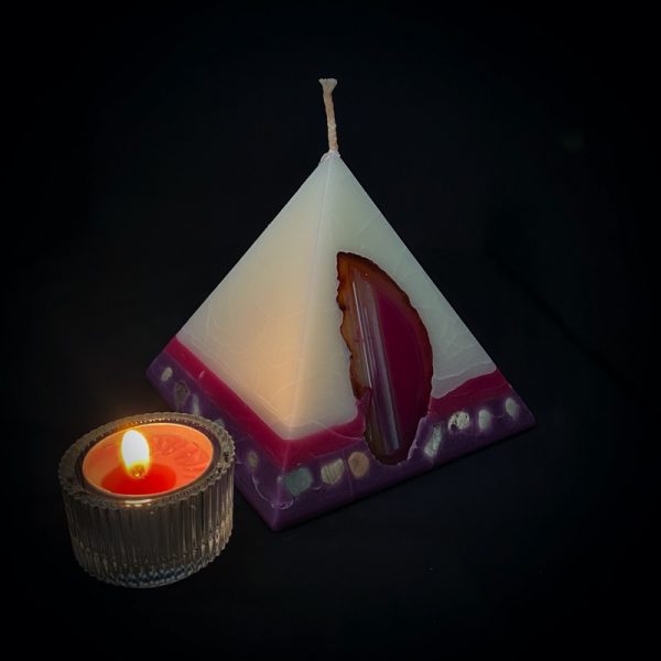 Tutankhamon: the smallest in our pyramid range, this candles burns over 90 hours. As your pyramid candle burns, the flame illuminates the Agate, revealing the stone's unique variegated patterns, and leaves you with a gorgeous keepsakes. Visually beautiful, this white bodied pyramid is banded at the base in purple and magenta and embedded with river pebble. Infused oils of Rose and Geranium create a luxurious scent with fresh and relaxing overtones. Our candles illuminate brightly and boast an exceptionally long burn time.