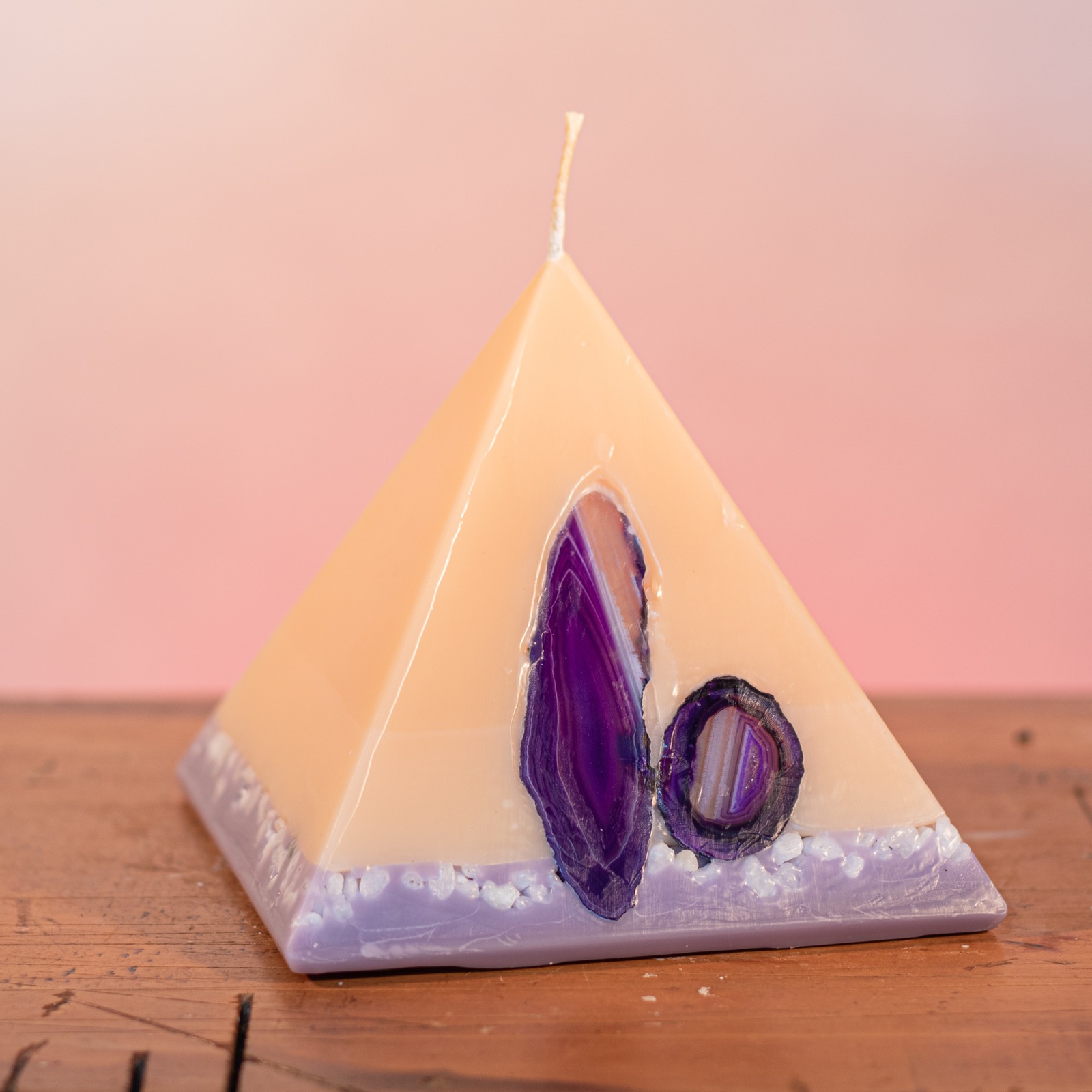 As your pyramid candle burns, the flame illuminates the Agate, revealing the stone's unique variegated patterns, and leaves you with a gorgeous keepsake. Essential oils of lavender and vanilla make this light cream coloured candle a favourite. It features a lilac base embedded with soft pastel river pebbles. As your pyramid candle burns, the flame illuminates the Agate, revealing the stone's unique variegated patterns, and leaves you with a gorgeous keepsake. Essential oils of lavender and vanilla make this light cream coloured candle a favourite. It features a lilac base embedded with soft pastel river pebbles.